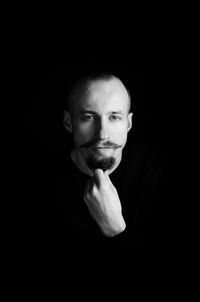 Portrait of man against black background