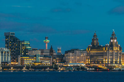 Illuminated buildings in city at waterfront