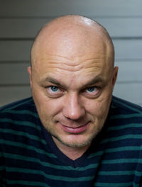 Close-up portrait of smiling bald man at home