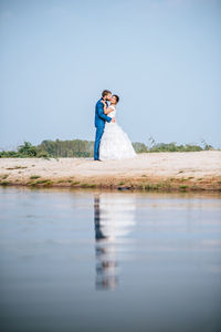 Woman standing on water against sky