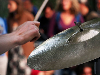 Cropped hand playing cymbal during event in city