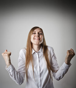 Portrait of a smiling young woman against white background