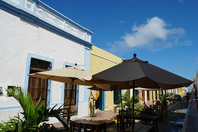 House and tables against sky in city