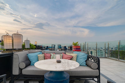 Chairs and tables at restaurant against sky