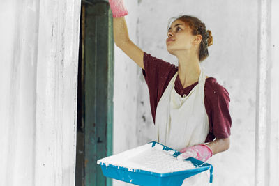 Portrait of young woman standing by window