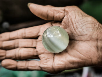 Cropped hand of person holding crystal ball