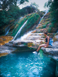 Man surfing on rock in water