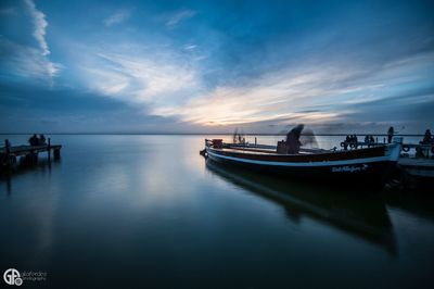 Boats in sea at sunset