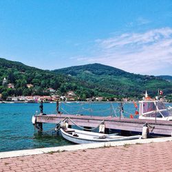 Boats in sea with mountain range in background