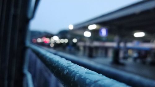 Defocused image of illuminated city street against clear blue sky