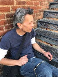 Full length of man lying on brick wall