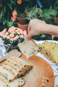 Close-up of hand holding bread on table