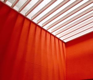Low angle view of red wall and patterned ceiling