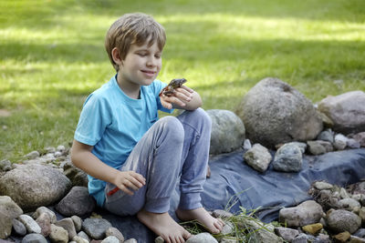 Boy sitting on rock