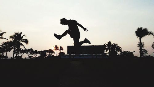 Low angle view of silhouette man playing against clear sky