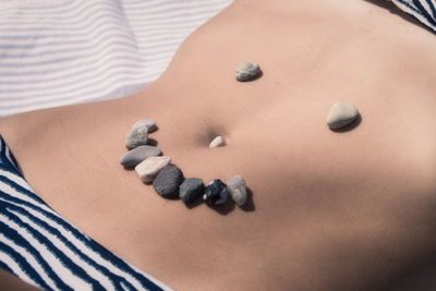 Midsection of woman lying on bed