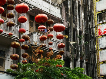 Low angle view of lanterns hanging by building