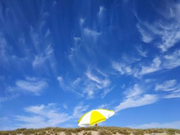 Low angle view of yellow flag against sky