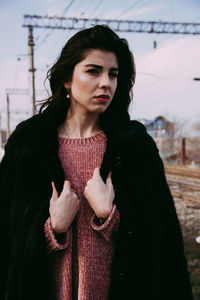 Young woman looking away while standing in winter