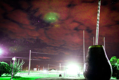 Illuminated street light against sky at night