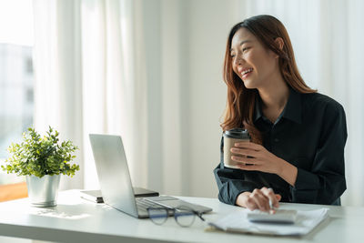 Young woman using mobile phone at office