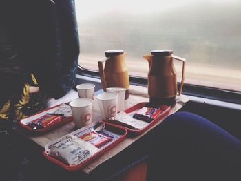 Low section of woman holding coffee cup on table