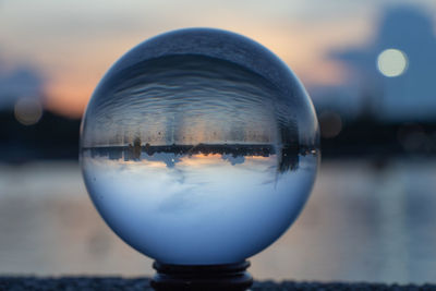 Close-up of crystal ball in water during sunset