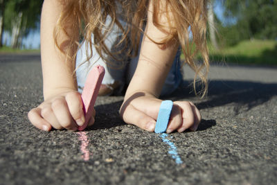 Close-up of a girl with hand on road