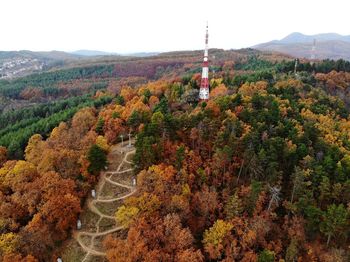 High angle view of tower amidst autumn trees against clear sky