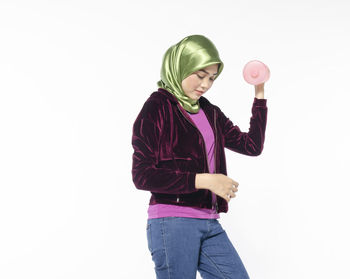 Woman standing against pink background