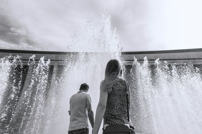 People standing against fountain in city