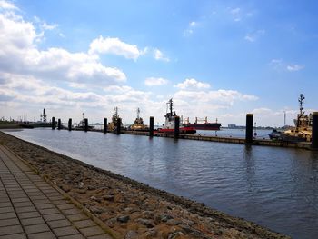 Boats moored in sea against sky in city