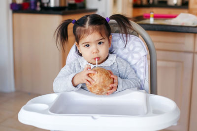 Portrait of cute girl eating food at home