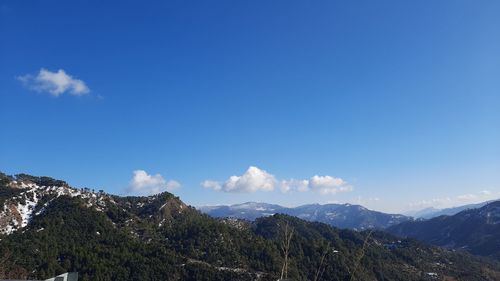 Scenic view of mountains against blue sky