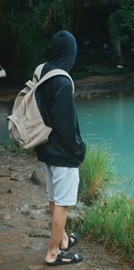 Rear view of man walking by plants