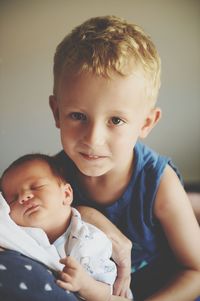 Portrait of cute boy holding brother at home