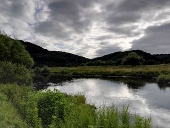 Scenic view of lake against cloudy sky