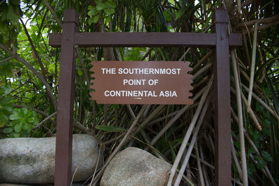 Close-up of information sign against trees