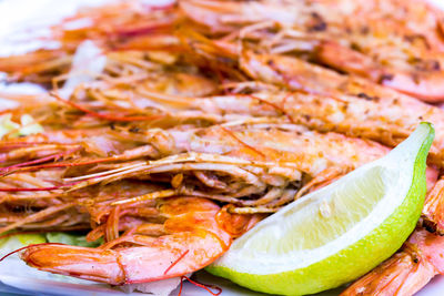 Close-up of shrimps with lemon served in plate