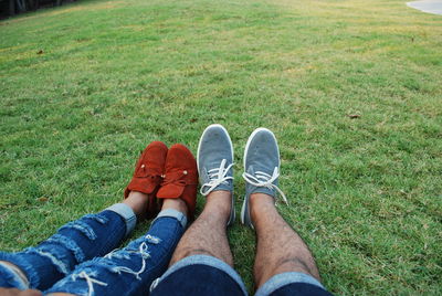 Low section of man wearing shoes on field