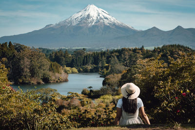 Rear view of woman by mountains against sky