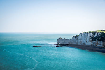 High angle view of mountain by sea against clear sky