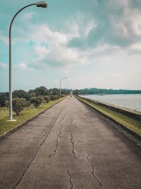 Empty road by street against sky