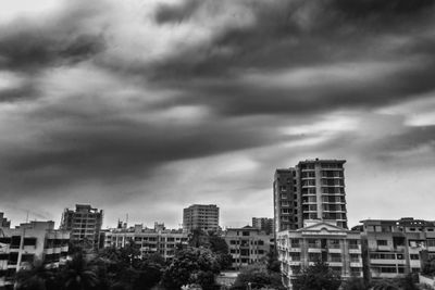 Buildings in city against cloudy sky