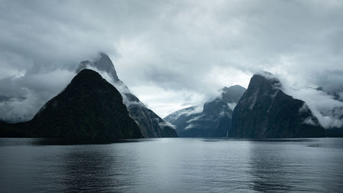 Scenic view of lake by mountains against sky