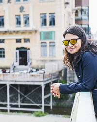 Woman with orange sunglasses looking at camera in osaka