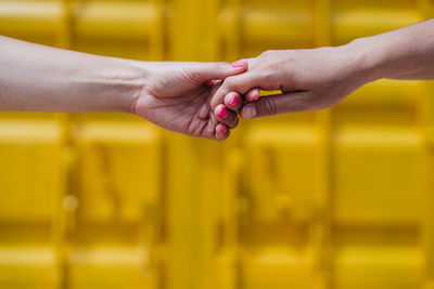 Close-up of woman hand on yellow glass