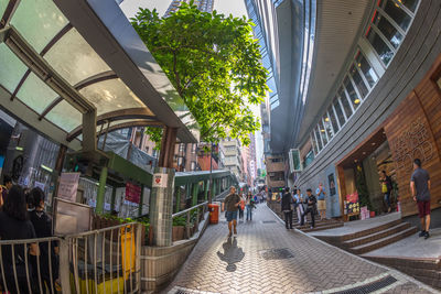 People walking on street amidst buildings in city