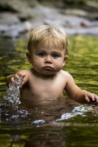 Portrait of cute boy swimming in lake