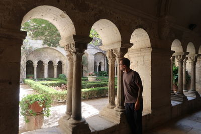 Rear view of man standing at historical building